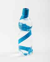 Photo gratuite bouteille d'eau isolée et centimètre bleu