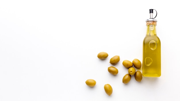 Bouteille d'huile d'olive aux olives jaunes et espace de copie