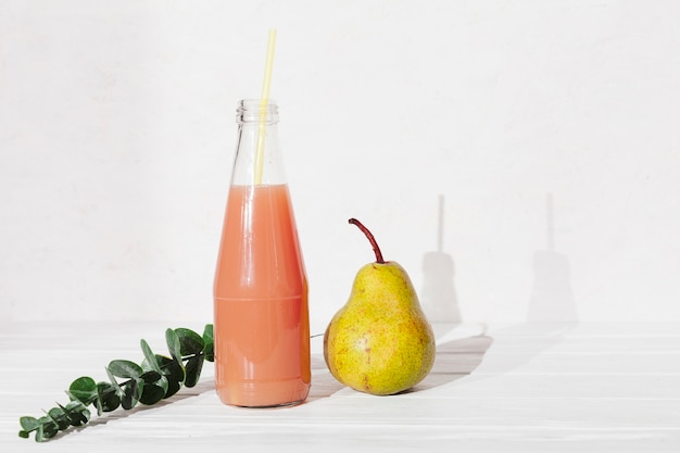 Bouteille de jus avec poire et feuilles