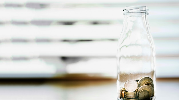 Photo gratuite une bouteille ouverte en verre devant la fenêtre