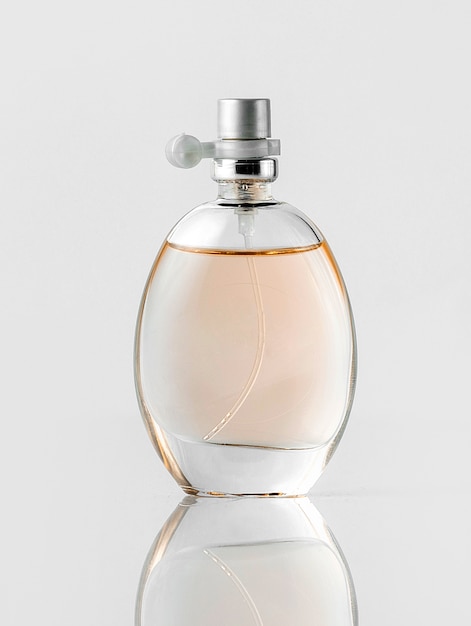 Une bouteille de parfum vue de face transparente sur le sol blanc