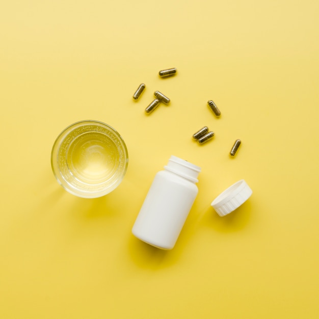 Photo gratuite bouteille de pilules avec verre d'eau