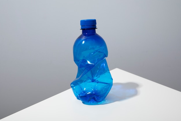 Photo gratuite bouteille en plastique à angle élevé sur tableau blanc