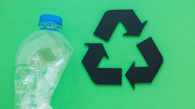 Photo gratuit bouteille en plastique à côté du panneau de recyclage