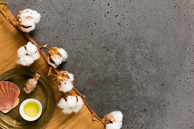 Photo gratuite bouteille de sel avec coquille de mer et huile près de pantalon de coton