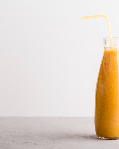 Bouteille de smoothie orange vue de face avec copie-espace