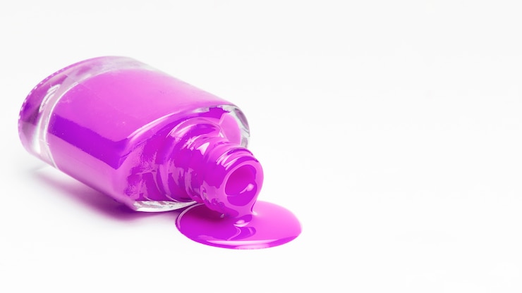 Photo gratuit bouteille de vernis à ongles rose tombé isolé sur une surface blanche