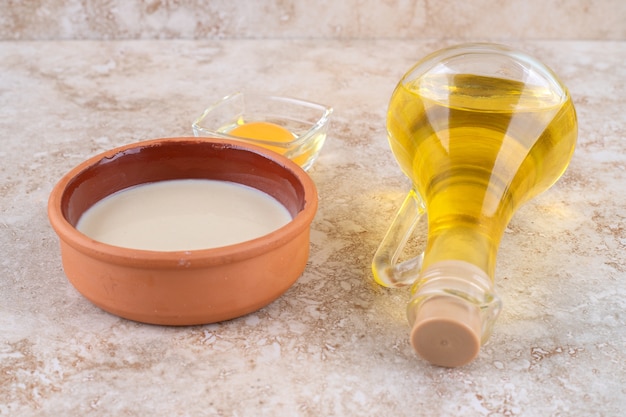 Une bouteille en verre d'huile et un œuf cru