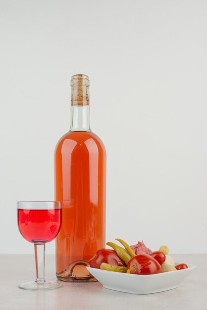 Bouteille avec verre de limonade et assiette de boulettes.