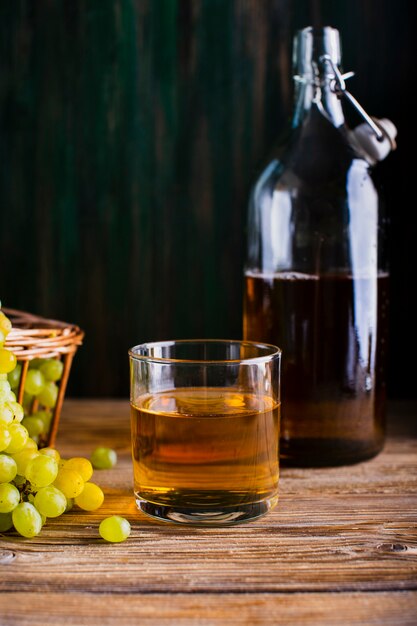 Bouteille et verre sur la table avec du jus de raisin frais