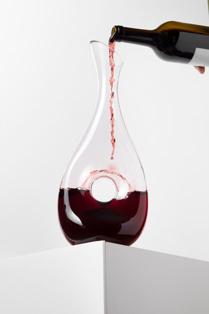 Bouteille versant du vin rouge dans la carafe