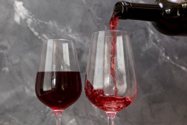Une bouteille de vin remplissant le verre à vin