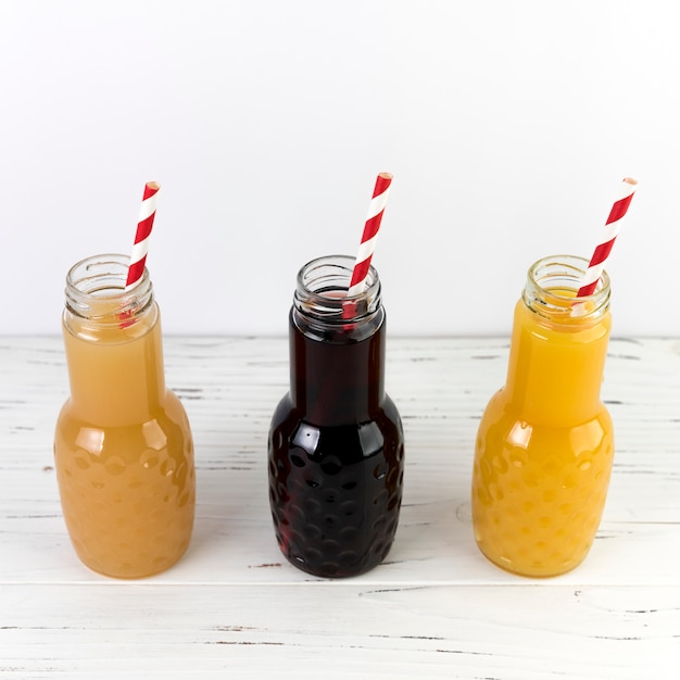 Bouteilles de jus vue de dessus sur une table en bois blanc