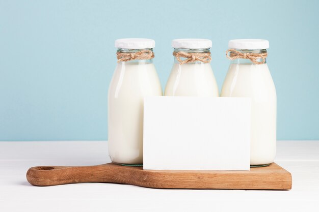 Bouteilles de lait et carte sur planche à découper