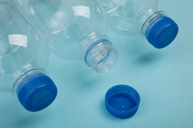 Photo gratuite bouteilles en plastique sur fond bleu grand angle