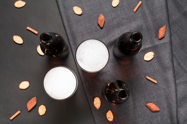 Bouteilles plates et verres de bière avec des snacks