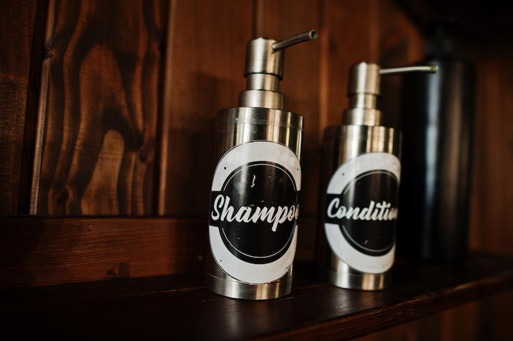 Photo gratuit bouteilles de shampoing et de revitalisant au salon de coiffure sur fond de bois