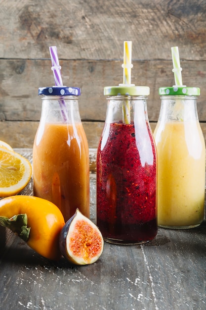 Bouteilles avec smoothie près des ingrédients