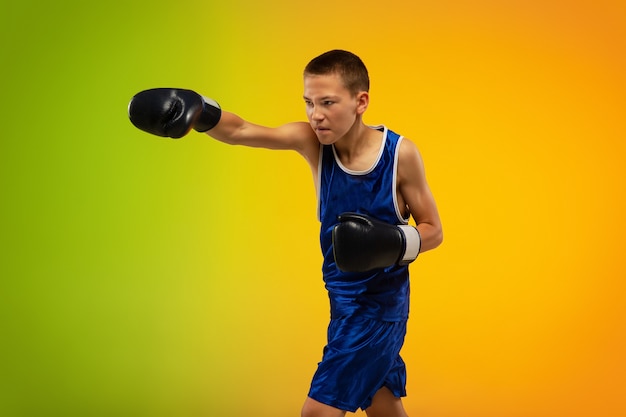 Boxer adolescent contre néon dégradé en mouvement de coups de pied, boxe