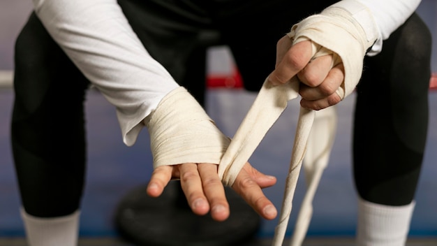 Boxer enveloppant ses mains avant de s'entraîner sur le ring