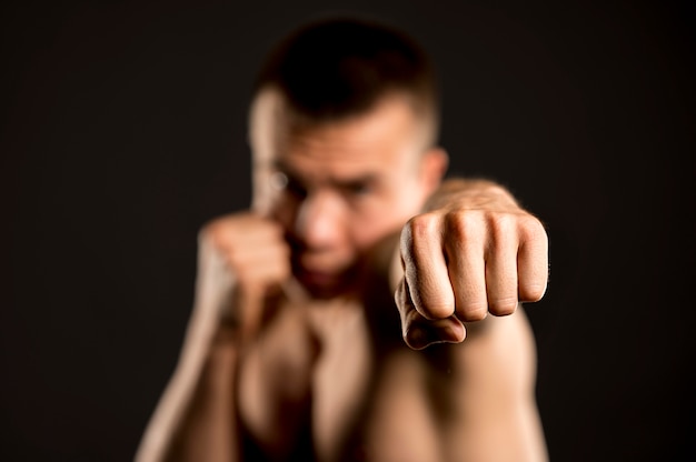 Photo gratuite boxer masculin défocalisé posant avec position de boxe