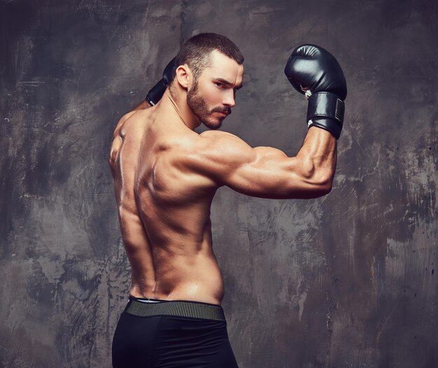 Un boxeur musclé brutal avec des gants de boxe travaillant sur la technique de frappe.