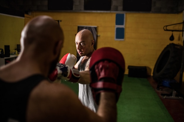 Boxeurs pratiquant la boxe dans le studio de fitness