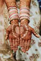 Photo gratuite bracelets de mariage indiens et mains colorées au henné mehandi avec ornement réfléchissant