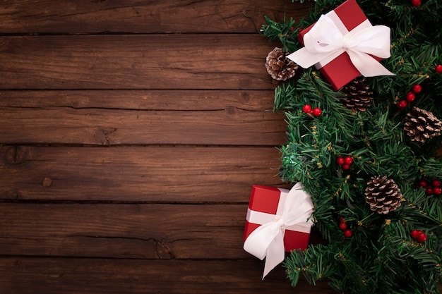 Branche d'arbre de Noël avec des cadeaux sur un fond en bois