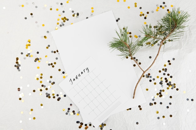 Branche de sapin avec calendrier de janvier sur table