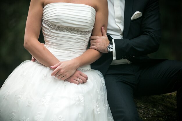 Bras de l&#39;homme saisissant le bras d&#39;une femme avec robe de mariée