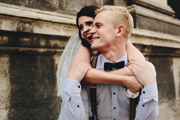 Photo gratuite bride étreindre son petit ami de l'arrière et rire