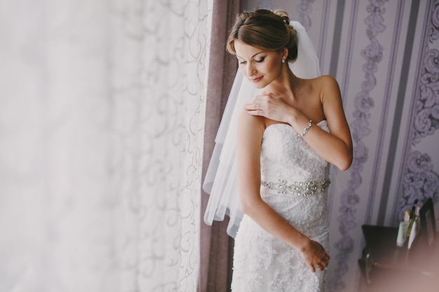 Photo gratuite bride examinant sa robe de mariée