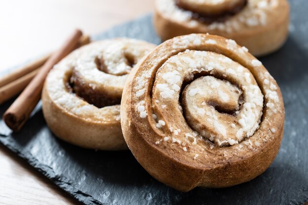 Brioches à la cannelle sur table en bois Kanelbulle dessert suédois