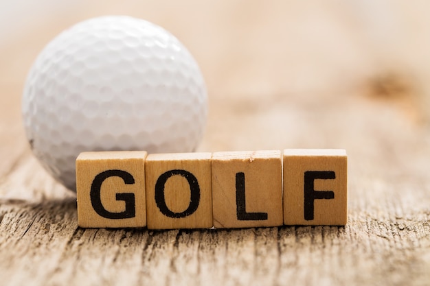 Briques de jouet sur la table avec mot GOLF et balle de golf
