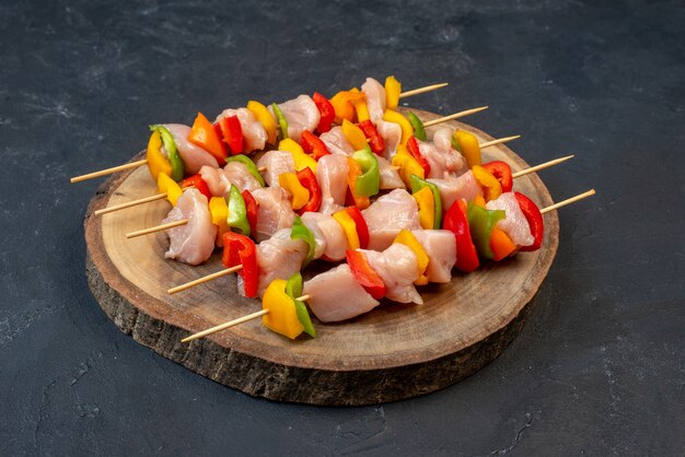 Brochette de poulet cru vue de dessous sur planche de bois sur table