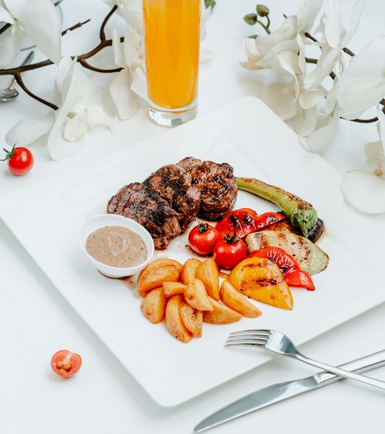 Brochette de viande avec des légumes frits sur la table