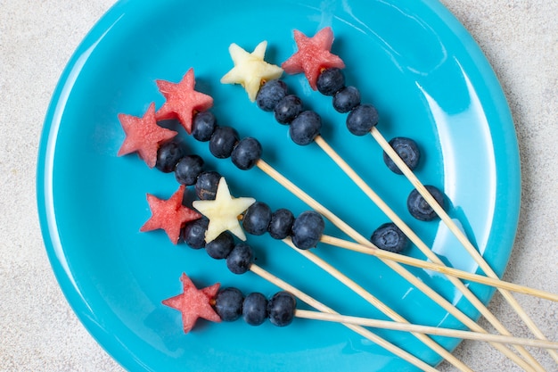 Brochettes de fruits de la fête de l'indépendance à plat sur la plaque