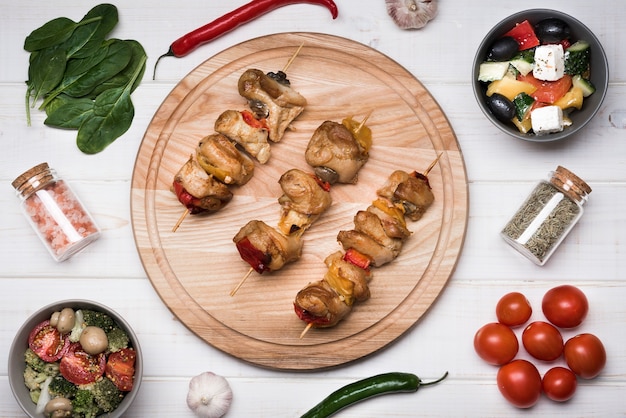 Brochettes plates sur planche de bois avec des ingrédients