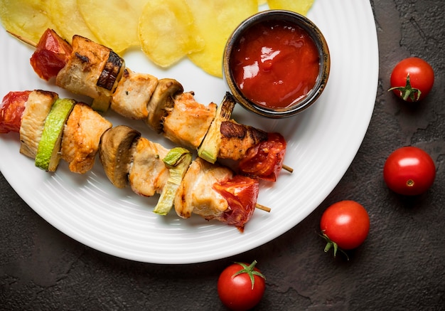 Brochettes de poulet vue de dessus avec sauce et frites sur assiette