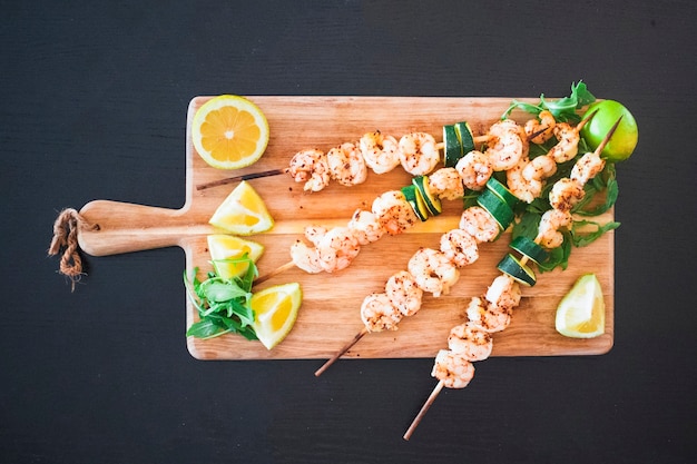 Brochettes de shish aux fruits de mer servies avec des agrumes