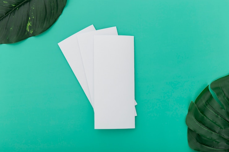 Photo gratuit brochures pliées avec des feuilles sur le bureau