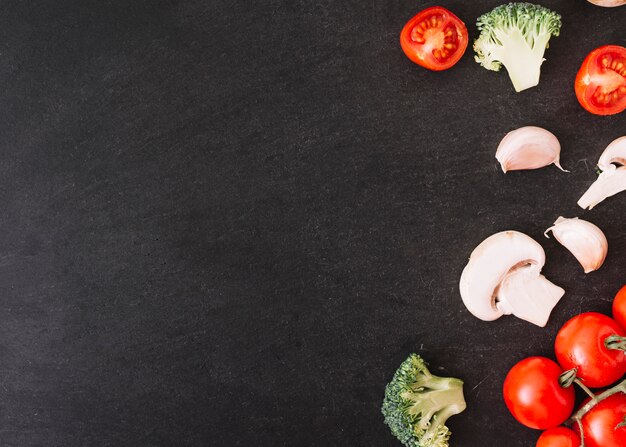 Brocoli; tomates cerises; gousses de champignons et d&#39;ail sur fond texturé blanc