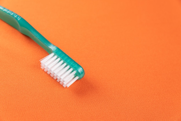 Brosse à dents verte sur la table orange