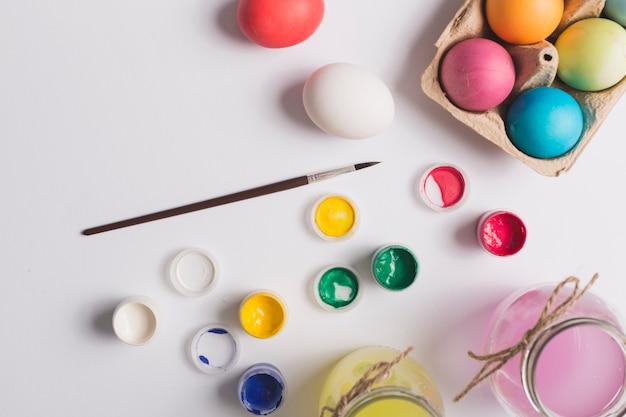 Brosse près des peintures et des oeufs