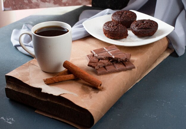 Brownies au cacao, barres de chocolat et une tasse de thé.