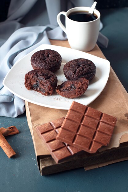 Brownies au chocolat avec une barre de chocolat au lait et une tasse de café.