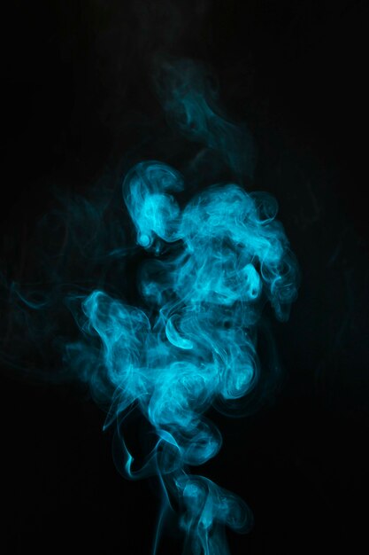 Brume bleue soufflant de la fumée sur fond noir