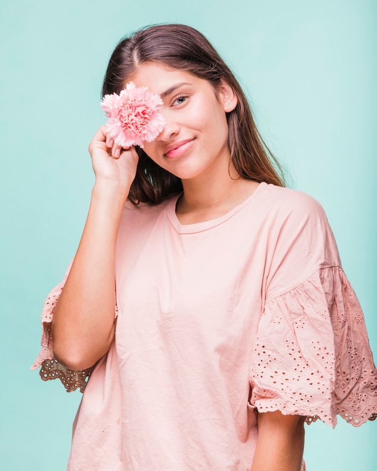 Photo gratuit une brune posant avec des fleurs.