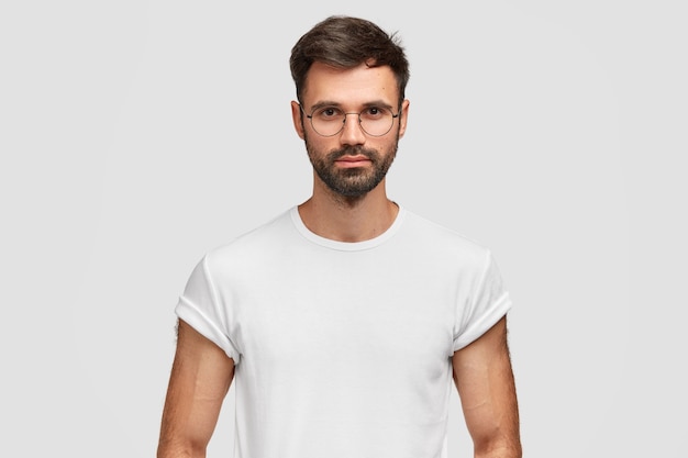 Brunet homme portant des lunettes rondes et un t-shirt blanc